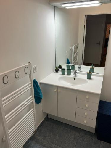 a bathroom with a white sink and a mirror at PARIS-MONTROUGE Magnifique appartement 3 pièces de 75m2 avec PARKING - très cosy pour 1 - 8 personnes refait à NEUF -ENTIRE APARTMENT LUXURIOUS AND WARM -Montrouge Paris 14ème - Proche Aéroport Orly Parc Expositions Porte de Versailles FREE WIFI GRATUIT in Montrouge