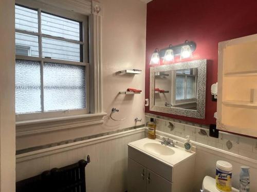 a bathroom with a sink and a mirror and a window at Large 2 Bed-Room Apt Across From Union College in Schenectady