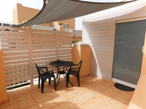 einen Tisch und Stühle auf dem Balkon eines Gebäudes in der Unterkunft Alojamiento Parque Corralejo in Corralejo