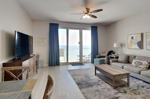 a living room with a television and a couch and a table at Inn at Summerwinds #1403 in Navarre