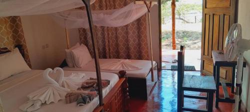 Kwangwazi的住宿－SELOUS RIVER VIEW LODGE，一间卧室配有两张双层床和遮阳伞。