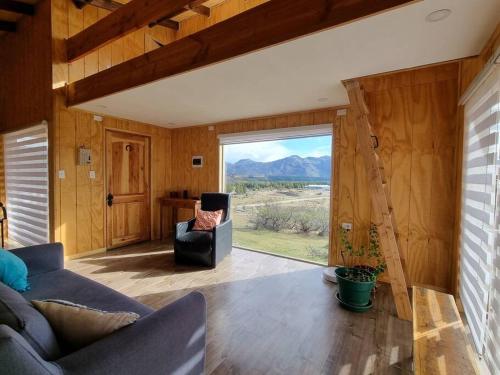 a living room with a chair and a large window at Descanso garantizado Cochrane in Cochrane