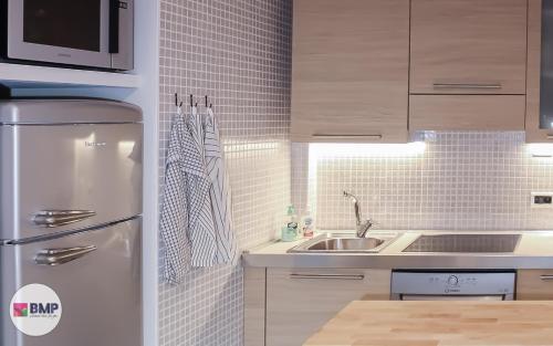 a kitchen with a refrigerator and a sink at Bmp apartment Molveno Relax in Molveno