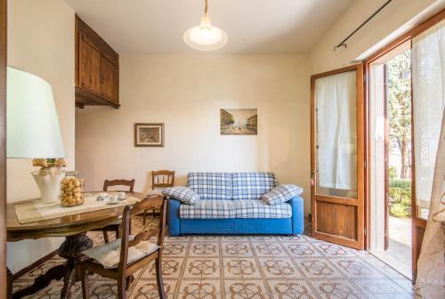 uma sala de estar com um sofá azul e uma mesa em La Casina di Radi em Monteroni dʼArbia