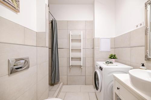 baño blanco con lavadora y lavamanos en DanubeGreen bright two bedroom apartment near Margaret Island, en Budapest