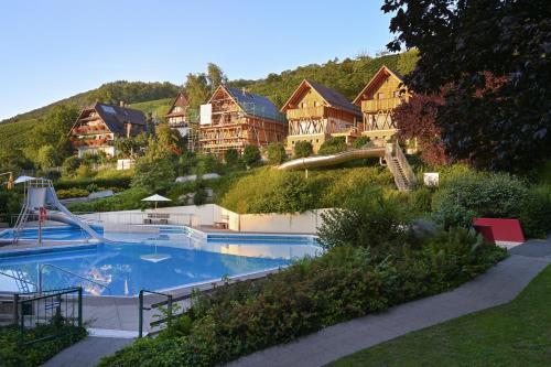 a large swimming pool in a resort with houses at Oma Ludwin in Sasbachwalden