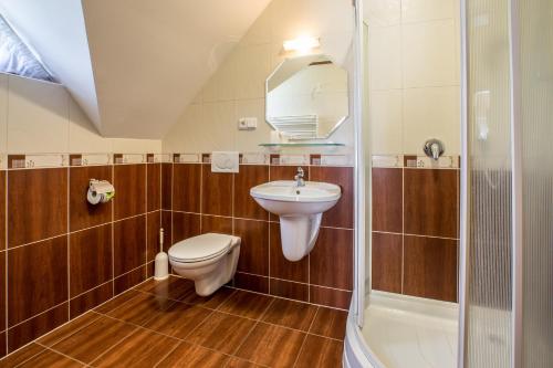 a bathroom with a toilet and a sink and a shower at Penzión Ingrid in Štrbské Pleso