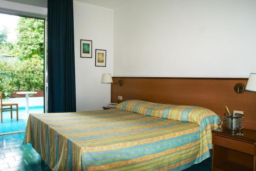 a hotel room with a bed and a balcony at Villa Ciccio in Ischia