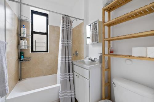 ein Badezimmer mit einer Badewanne, einem Waschbecken und einem WC in der Unterkunft Live Upper Manhattan on a Budget in New York