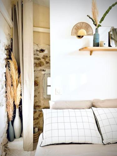 una camera con un letto e una finestra con vasi di Maison Louisa 