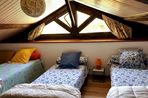 a room with two twin beds in a attic at Gite de charme en pierres apparentes : Les Granges in Gardonne