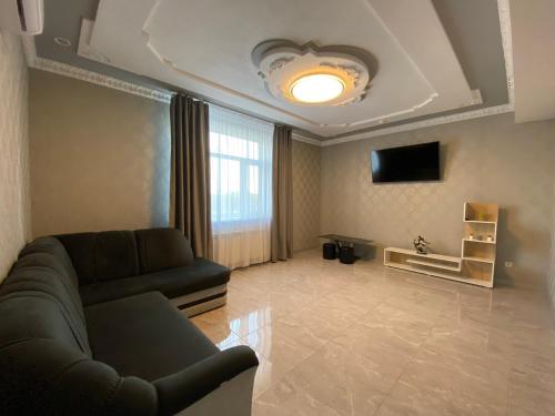 uma sala de estar com um sofá e uma televisão em ГРК РЕЛАКС em Pavlohrad