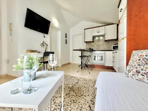 ein Wohnzimmer mit einem Bett und einem Tisch mit Weingläsern in der Unterkunft Miranda Penthouse AD with FREE PARKING in Puerto de la Cruz