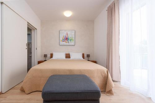 1 dormitorio con 1 cama grande con reposapiés azul en Villa Paloma with pool, en Sukošan