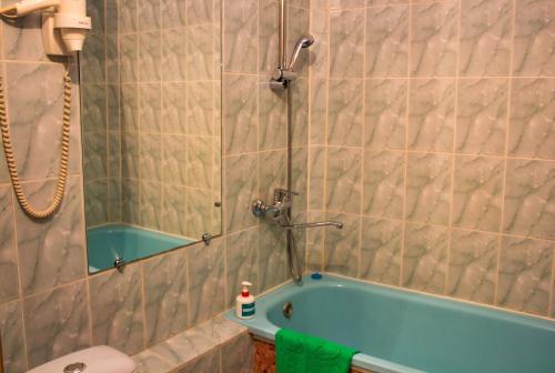 a bathroom with a tub and a shower and a toilet at Есения in Petropavlovsk