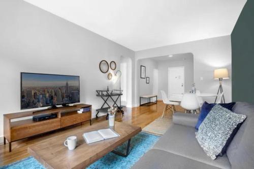 uma sala de estar com um sofá e uma televisão de ecrã plano em Warm and Comfortable 3 BR em Nova York