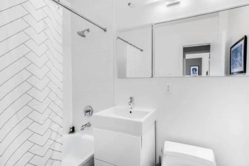 uma casa de banho branca com um lavatório e um espelho em Warm and Comfortable 3 BR em Nova York