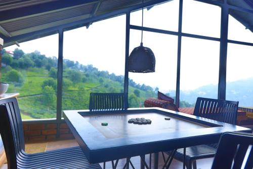 a table and chairs in a room with a large window at Moonlight Chillers By LexStays in Yedapalli
