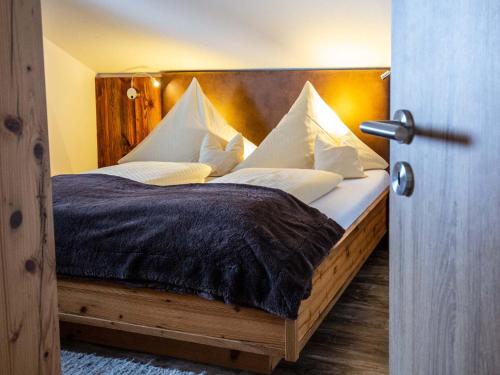 a bedroom with a large bed with white pillows at Adlernest in Riezlern