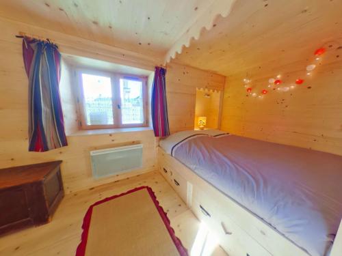 a bedroom with a bed in a wooden cabin at Chalet Hauteluce, 3 pièces, 8 personnes - FR-1-594-63 in Hauteluce