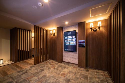 un couloir avec un écran vidéo dans un bâtiment dans l'établissement Hotel　このへんのアジア, à Kyoto