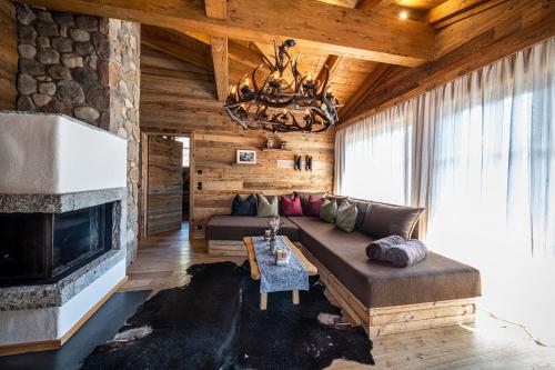 a living room with a couch and a fireplace at Alpe Chalets Goldener Hirsch in Scharnitz
