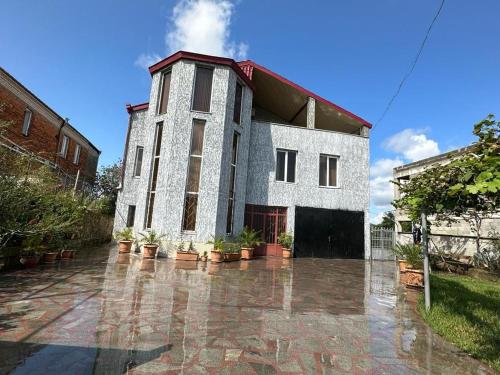 a large building with potted plants in front of it at Happy House in Kutaisi