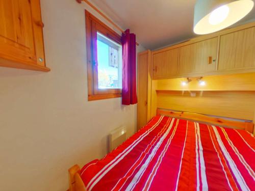 uma cama listrada em vermelho e branco num quarto em Appartement Les Saisies, 2 pièces, 4 personnes - FR-1-594-129 em Hauteluce
