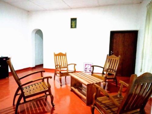 um quarto com 4 cadeiras de madeira e uma mesa em Green Agua Lodge em Belihuloya