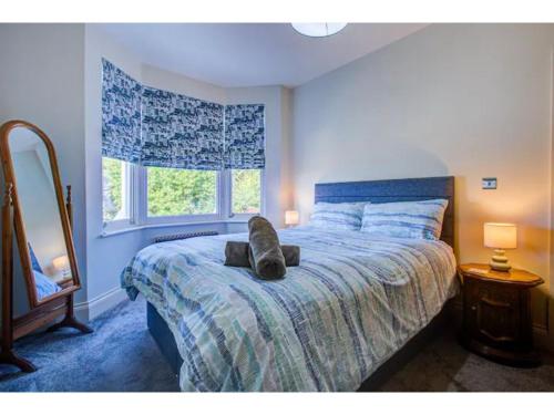 ein Schlafzimmer mit einem Bett mit einem ausgestopften Tier darauf in der Unterkunft Pass the Keys Stunning house in Leigh in Southend-on-Sea