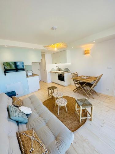 un salon avec un canapé blanc et une table dans l'établissement Appart'Hôtel & Spa 