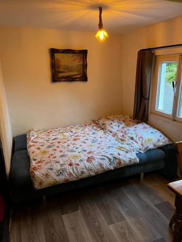 a bedroom with a bed with a floral comforter at Wohnen auf dem Bauernhof in Herdecke