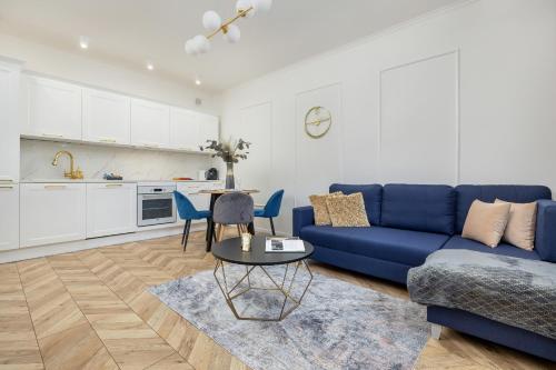 a living room with a blue couch and a table at Beautiful One Bedroom Apartment Zamkowa by Rent like home in Gdańsk