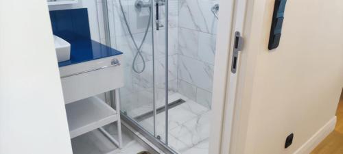 une douche avec une porte vitrée dans une salle de bain dans l'établissement Orbi City Blok D, à Batoumi