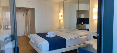 une chambre avec un grand lit blanc avec un miroir dans l'établissement Orbi City Blok D, à Batoumi