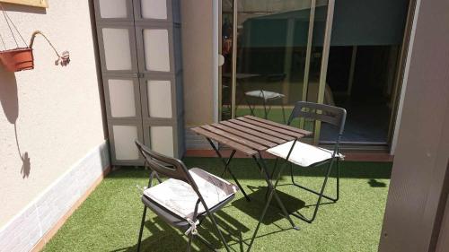 a wooden table and two chairs on a patio at Apartamento en La Tejita-El Médano. Familia Vilmar in Granadilla de Abona