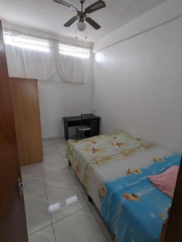 una camera con letto e ventilatore a soffitto di Appartment in residential area a Quatre Bornes
