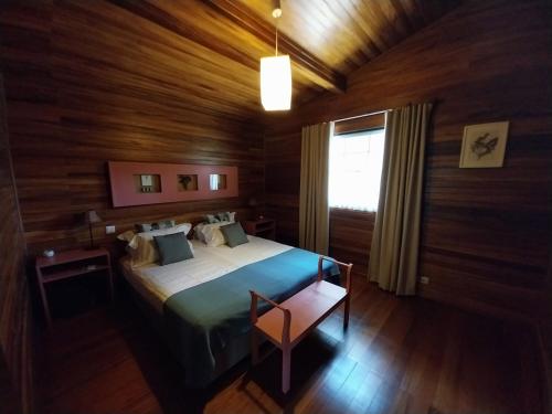 - une chambre avec un lit doté de murs en bois et d'une fenêtre dans l'établissement Aldeamento Turístico da Companhia das Lezírias, à Samora Correia