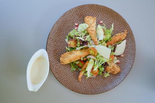 a plate of food with a salad and dressing at Le Côté Vert in Waterloo