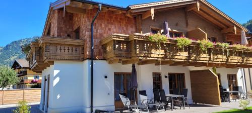 uma casa com varanda com mesas e cadeiras em Hochalmbahnen Chalets Rauris 1-20 WE4, Maislaufeldweg 1r OG em Rauris