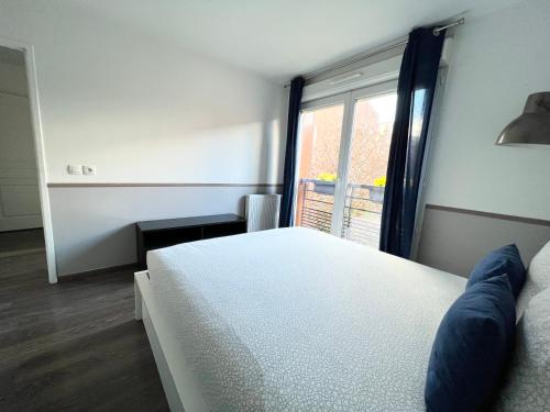 een slaapkamer met een wit bed en een raam bij Design Apartment Disneyland Paris in Chessy