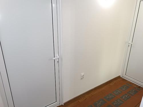 a white refrigerator in a room with a wooden floor at Vikendica Ovčar Banja in Čačak