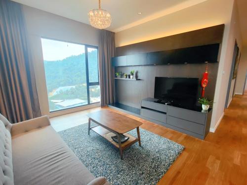 a living room with a couch and a table and a tv at Geo38 Genting 3Bed2Bath 10 pax High Floor Free WiFi in Genting Highlands