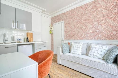 un salon avec un canapé et une cuisine dans l'établissement Green apartment Paris city center, à Paris