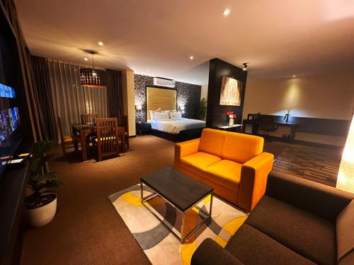 Habitación de hotel con cama y sala de estar. en Viceroy Luxury Mountain Resort and Spa, en Munnar