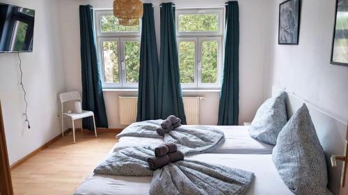 two beds in a room with two windows at Nice Apartment in Apolda in Apolda
