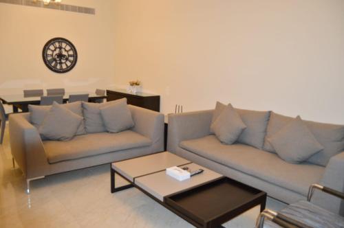 a living room with two couches and a table at Ginger Luxury House in Juffair