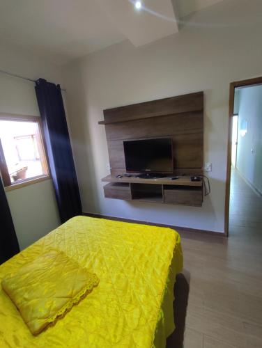 - une chambre avec un lit et une télévision à écran plat dans l'établissement pousada santos, à Jacuí