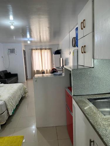 una cocina con fregadero y una cama en una habitación en Cebu City Studio Condo Unit-WIFI-A/C-Hot Shower-(U302) en Cebú