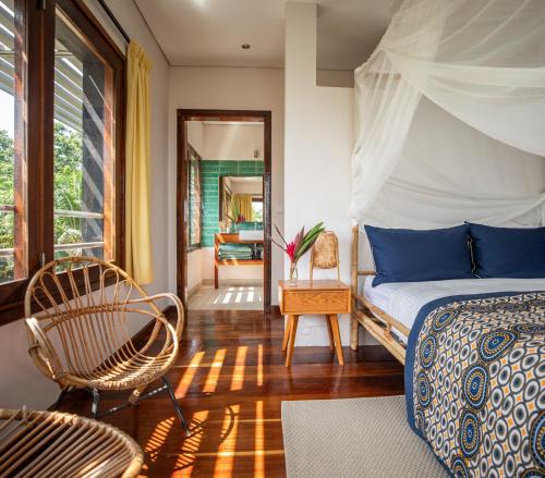 a bedroom with a bed and a chair at Villa Principe in Santo António
